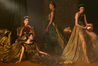 Quatro modelos com vestidos longos em tons de dourado, da Dior, contra um fundo escuro